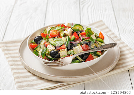 greek salad of veggies, olives, cheese in bowl 125394803