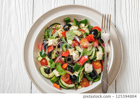 greek salad of veggies, olives, cheese in bowl 125394804