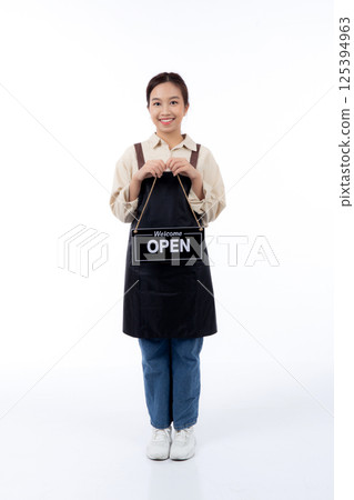 Portrait young asian barista woman wearing apron holding open sign for inviting customer to enter with happiness, waitress woman holding signboard with open, small business or startup business. Portrait young asian barista woman wearing apron holding open sign for inviting customer to enter with happiness, waitress woman holding signboard with open, small business or startup business. 125394963