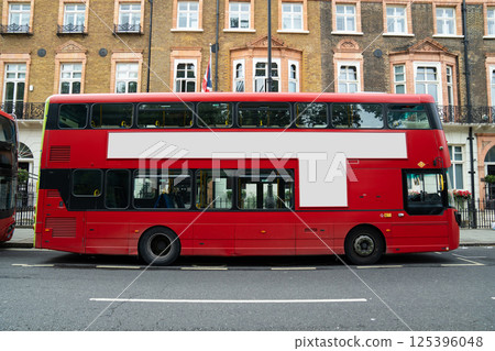 The blank ad space on the red bus contrasts with the classic charm of the calm London street. The blank ad space on the red bus contrasts with the classic charm of the calm London street. 125396048