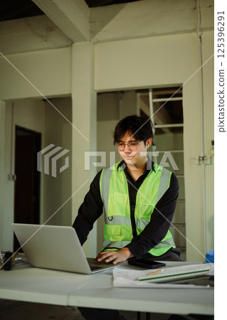 Engineer works on laptop at temporary desk inside a renovation site 125396291