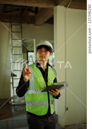 Construction supervisor with digital tablet evaluating project progress in renovation site 125396292