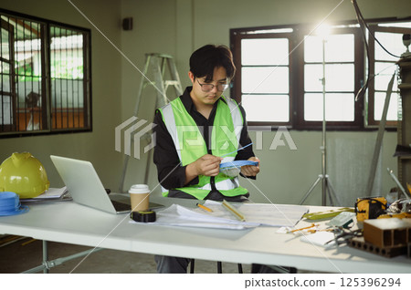 Electrician preparing cable ties for installation at temporary site desk Electrician preparing cable ties for installation at temporary site desk 125396294