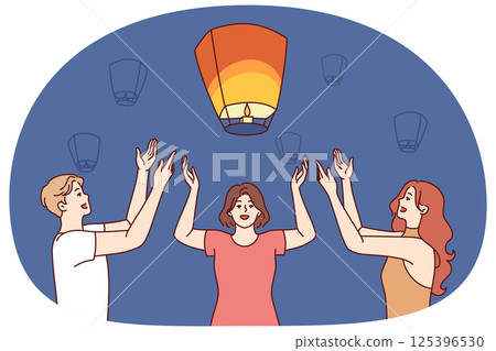 Friends launch chinese air lanterns together to make wish during festive night festival Friends launch chinese air lanterns together to make wish during festive night festival 125396530
