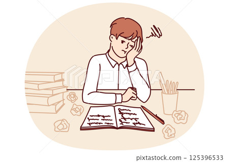 Thinking little schoolboy does homework sitting at table with books and workbook 125396533