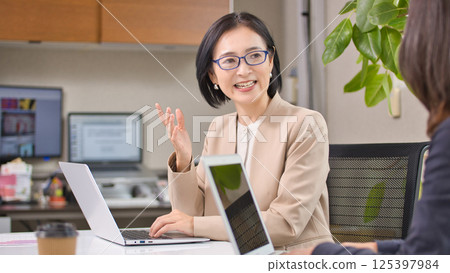 Middle-aged woman having a meeting in the office Middle-aged woman having a meeting in the office 125397984