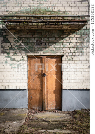 Rustic Door with Cracked Paint and Weathered Wall. Rustic Door with Cracked Paint and Weathered Wall. 125398158
