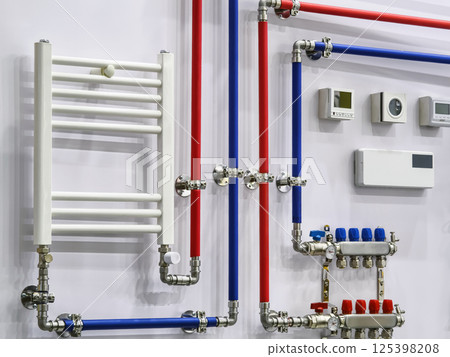 Pipes and valves displayed on a wall in a plumbing showroom with elements for heating and temperature control in an urban setting Pipes and valves displayed on a wall in a plumbing showroom with elements for heating and temperature control in an urban setting 125398208