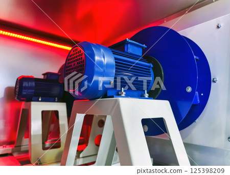 Blue electric motors installed in a controlled environment with red lighting effects Blue electric motors installed in a controlled environment with red lighting effects 125398209