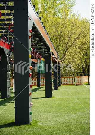 Sports ground outdoors for kids and adult. Successful training concept. Open air gym, street workout concept. Hanging monkey bars on kids playground. Sports ground outdoors for kids and adult. Successful training concept. Open air gym, street workout concept. Hanging monkey bars on kids playground. 125398238