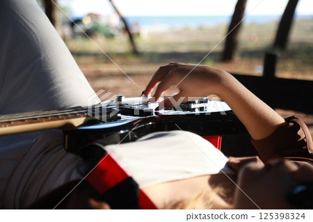 Girl Plays Bass Musical Instrument Lying On Table In Mountains Girl Plays Bass Musical Instrument Lying On Table In Mountains 125398324