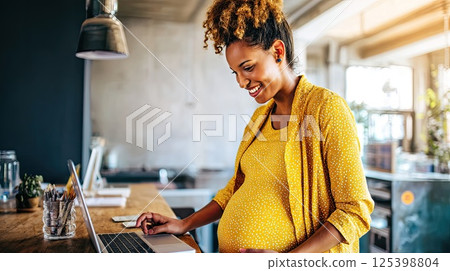 Young pregnant African American woman in front of laptop monitor at home. A close-up of a happy pregnant woman on a video call, eagerly discussing her health with the doctor. Young pregnant African American woman in front of laptop monitor at home. A close-up of a happy pregnant woman on a video call, eagerly discussing her health with the doctor. 125398804