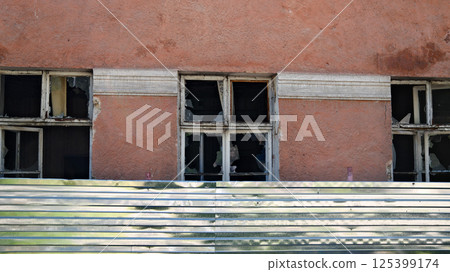 Building with damaged windows showing architectural decay 125399174