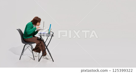Elderly woman leaning close to laptop screen with intense focus while studying alone at modern desk, reflecting digital education in senior years. Elderly woman leaning close to laptop screen with intense focus while studying alone at modern desk, reflecting digital education in senior years. 125399322