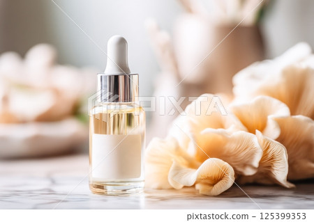 Dropper bottle of skincare serum next to mushrooms on a marble surface, representing natural fungal ingredients in modern beauty and skincare formulations. 125399353