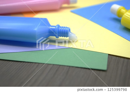 Colored construction paper and a tube of glue Colored construction paper and a tube of glue 125399798