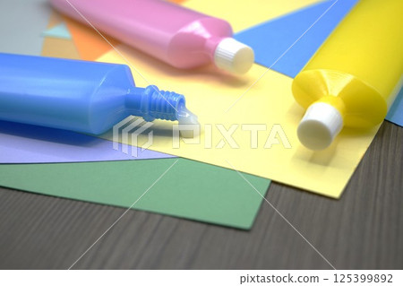 Colored construction paper and a tube of glue Colored construction paper and a tube of glue 125399892