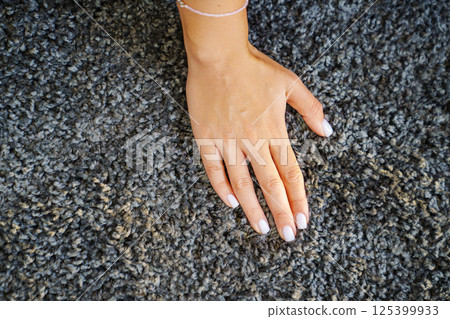 a woman's hand touching the grey Interior pile carpet a woman's hand touching the grey Interior pile carpet 125399933