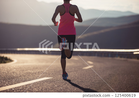 Fitness woman runner running in sunset mountain road Fitness woman runner running in sunset mountain road 125400619