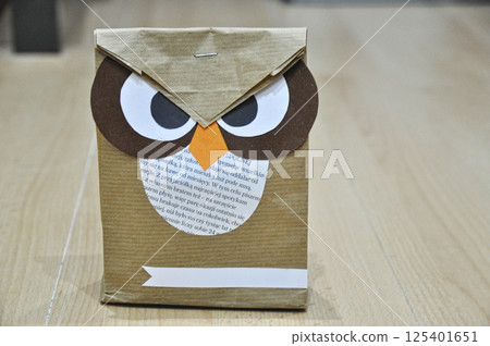 A gift package made from gray paper and newspapers in the shape of an owl 125401651