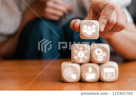 Wooden blocks with digital icons symbolize user-generated content and online community building in a modern digital context. 125401703