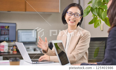 Middle-aged woman having a meeting in the office Middle-aged woman having a meeting in the office 125401986