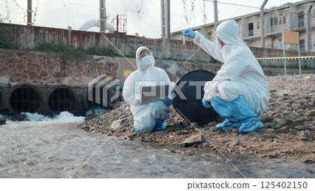 Ecologist sample water from the river and get fishes dead to check effected case in laboratory, Biologist wear protect suit and mask collects sample of waste water from industrial, problem environment Ecologist sample water from the river and get fishes dead to check effected case in laboratory, Biologist wear protect suit and mask collects sample of waste water from industrial, problem environment 125402150