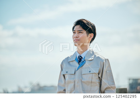 A young man in his 20s wearing work clothes gazing into the distance A young man in his 20s wearing work clothes gazing into the distance 125402295