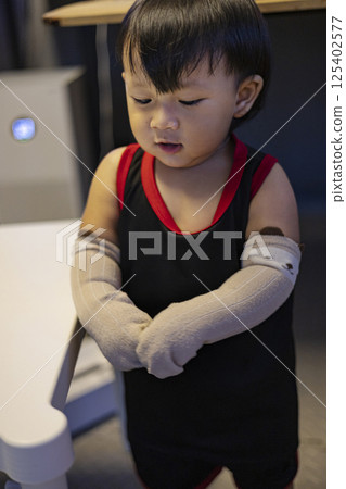 Toddler Tries On Socks On His Arms, Background for advertising and wallpaper in education and lifestyle scene. 125402577