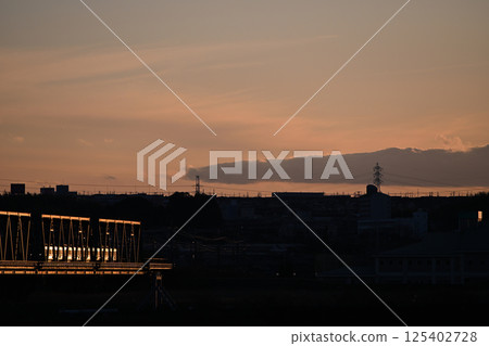 The silhouette of a railway bridge and a train shining at dusk 125402728