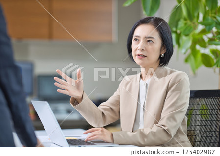 Middle-aged woman having a meeting in the office Middle-aged woman having a meeting in the office 125402987