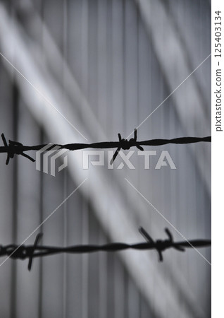 concrete gray windows in old fabric builiding architecture rusty fence with spikes 125403134