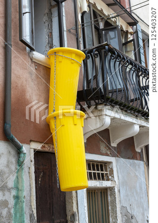 Yellow Debris Chutes Hanging from Window 125403207