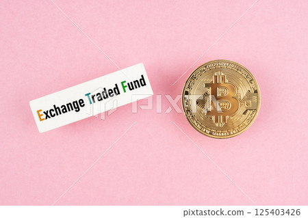 Bitcoin coin with Exchange Traded Fund ETF text on pink background. 125403426