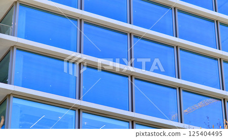 Downtown corporate business district architecture. Glass reflective office buildings against blue sky and sun light. Economy, finances, business activity concept. Rising sun on the horizon. 125404495