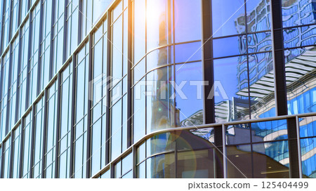 Downtown corporate business district architecture. Glass reflective office buildings against blue sky and sun light. Economy, finances, business activity concept. Rising sun on the horizon. Downtown corporate business district architecture. Glass reflective office buildings against blue sky and sun light. Economy, finances, business activity concept. Rising sun on the horizon. 125404499