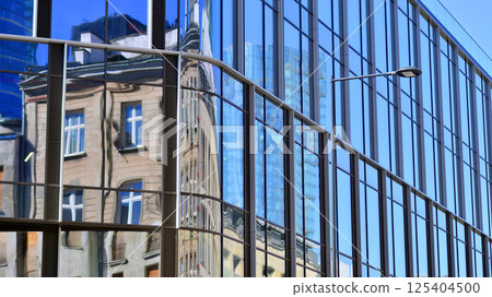 Downtown corporate business district architecture. Glass reflective office buildings against blue sky and sun light. Economy, finances, business activity concept. Rising sun on the horizon. 125404500