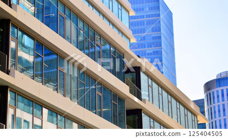 Downtown corporate business district architecture. Glass reflective office buildings against blue sky and sun light. Economy, finances, business activity concept. Rising sun on the horizon. Downtown corporate business district architecture. Glass reflective office buildings against blue sky and sun light. Economy, finances, business activity concept. Rising sun on the horizon. 125404505