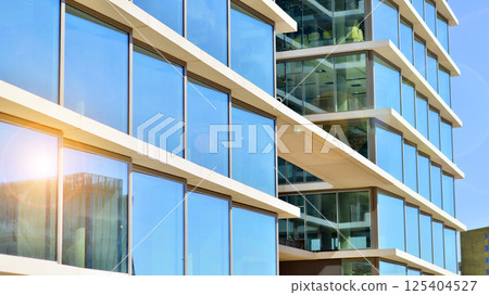 Downtown corporate business district architecture. Glass reflective office buildings against blue sky and sun light. Economy, finances, business activity concept. Rising sun on the horizon. Downtown corporate business district architecture. Glass reflective office buildings against blue sky and sun light. Economy, finances, business activity concept. Rising sun on the horizon. 125404527