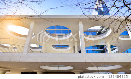 Downtown corporate business district architecture. Glass reflective office buildings against blue sky and sun light. Economy, finances, business activity concept. Rising sun on the horizon. 125404535