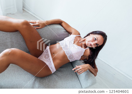 woman in light lingerie lying in the bedroom on the bed in the evening 125404601