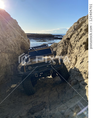 一輛無線電遙控的SUV行駛在大自然的岩石地形中 一輛無線電遙控的SUV行駛在大自然的岩石地形中 125404701