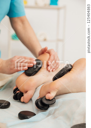 Woman on table at masseur on back massage in spa Woman on table at masseur on back massage in spa 125404863