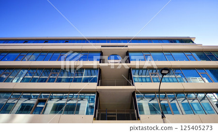 Downtown corporate business district architecture. Glass reflective office buildings against blue sky and sun light. Economy, finances, business activity concept. Rising sun on the horizon. 125405273