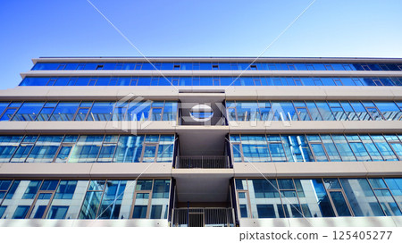 Downtown corporate business district architecture. Glass reflective office buildings against blue sky and sun light. Economy, finances, business activity concept. Rising sun on the horizon. Downtown corporate business district architecture. Glass reflective office buildings against blue sky and sun light. Economy, finances, business activity concept. Rising sun on the horizon. 125405277