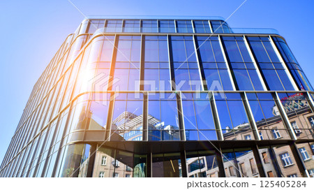 Downtown corporate business district architecture. Glass reflective office buildings against blue sky and sun light. Economy, finances, business activity concept. Rising sun on the horizon. Downtown corporate business district architecture. Glass reflective office buildings against blue sky and sun light. Economy, finances, business activity concept. Rising sun on the horizon. 125405284
