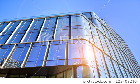 Downtown corporate business district architecture. Glass reflective office buildings against blue sky and sun light. Economy, finances, business activity concept. Rising sun on the horizon. Downtown corporate business district architecture. Glass reflective office buildings against blue sky and sun light. Economy, finances, business activity concept. Rising sun on the horizon. 125405286