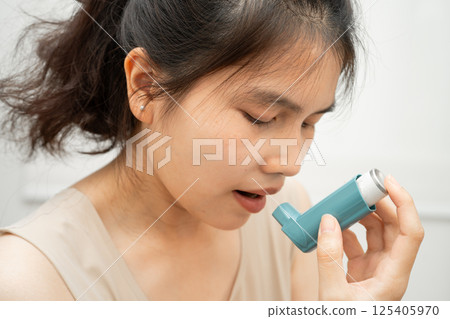 Asian woman use Asthma and chronic obstructive pulmonary disease COPD, Asian young man using metered dose inhaler MDI. Asian woman use Asthma and chronic obstructive pulmonary disease COPD, Asian young man using metered dose inhaler MDI. 125405970