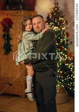 dad and little daughter at the Christmas tree.  125406549