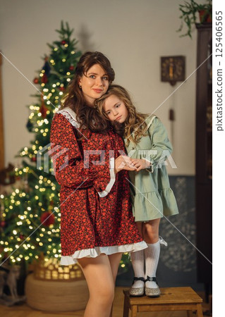Beautiful mother and daughter at the Christmas tree.  125406565